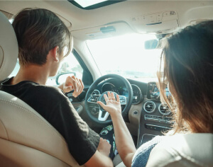 A boy behind the wheel with the instructor